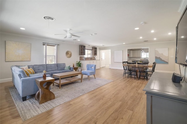 2119 Rabb Rd, Austin, TX 78704 - living room with crown molding, ceiling fan, recessed lighting, healthy amount of natural light, and light wood-style floors