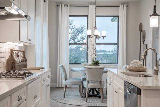106 Double Eagle Ranch Dr, Cedar Creek, TX 78612 - kitchen with under cabinet range hood, appliances with stainless steel finishes, white cabinetry, decorative backsplash, and a chandelier