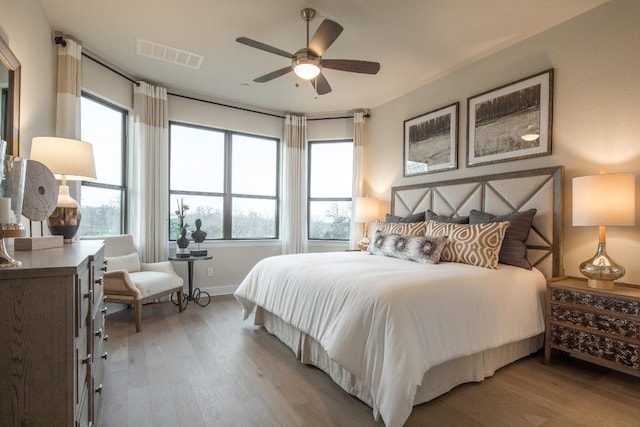 106 Double Eagle Ranch Dr, Cedar Creek, TX 78612 - bedroom with wood finished floors, multiple windows, and ceiling fan