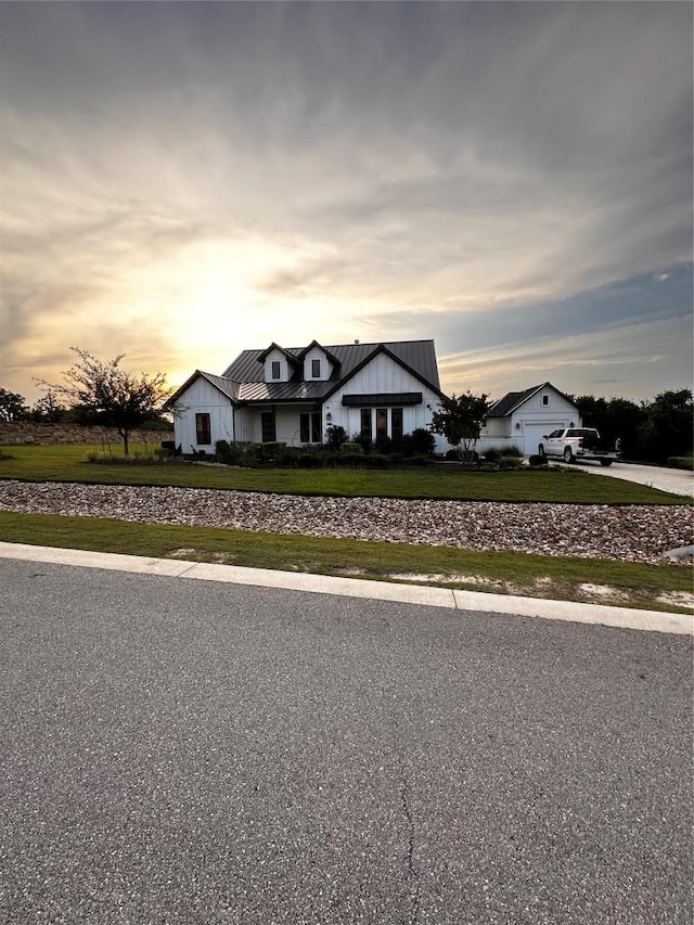 106 Double Eagle Ranch Dr, Cedar Creek, TX 78612 - modern farmhouse style home with board and batten siding, a standing seam roof, a metal roof, concrete driveway, and an attached garage