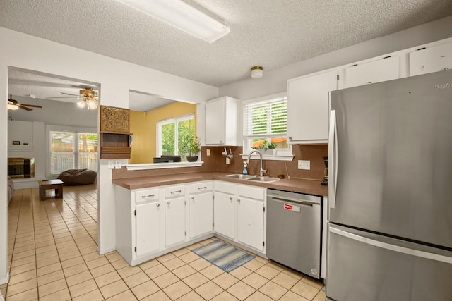 2810 Goldbridge Dr, Austin, TX 78745 - kitchen with stainless steel appliances, a textured ceiling, light tile patterned flooring, white cabinetry, and ceiling fan