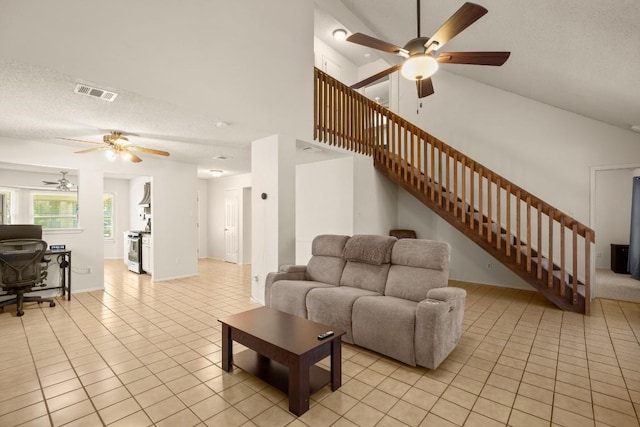 2810 Goldbridge Dr, Austin, TX 78745 - living area featuring a ceiling fan, light tile patterned floors, stairway, a towering ceiling, and a textured ceiling