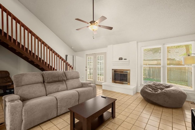 2810 Goldbridge Dr, Austin, TX 78745 - living area featuring light tile patterned floors, a ceiling fan, plenty of natural light, a fireplace, and high vaulted ceiling
