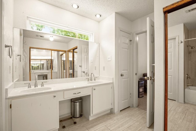 2810 Goldbridge Dr, Austin, TX 78745 - full bath featuring double vanity, a textured ceiling, and  shower combination