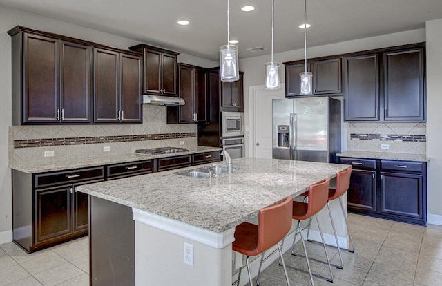 5821 Viejo Dr, Austin, TX 78738 - kitchen with stainless steel appliances, light tile patterned flooring, a kitchen bar, dark brown cabinetry, and backsplash