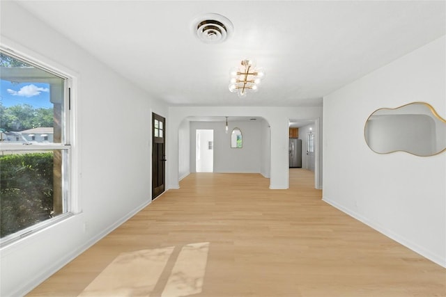 1302 S 2nd St, Killeen, TX 76541 - hallway with arched walkways, light wood-style floors, and a chandelier