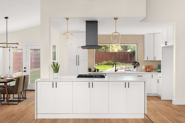 6903 Narrow Oak Trl, Austin, TX 78759 - kitchen featuring range hood, light countertops, gas cooktop, white cabinets, and hanging light fixtures