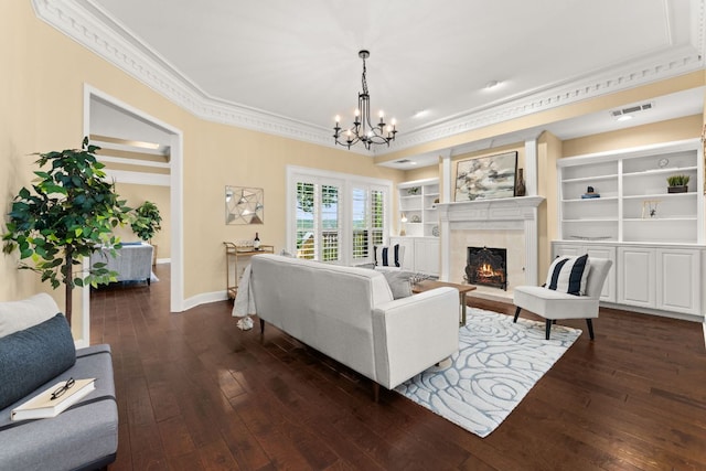 4206 River Place Blvd, Austin, TX 78730 - living room featuring crown molding, dark wood-style floors, a chandelier, a fireplace, and built in shelves
