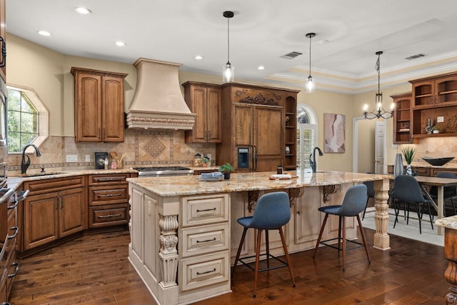 4206 River Place Blvd, Austin, TX 78730 - kitchen featuring open shelves, custom exhaust hood, dark wood finished floors, tasteful backsplash, and a breakfast bar area