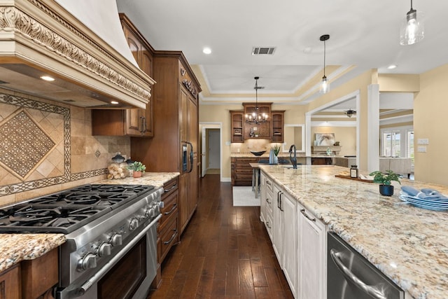 4206 River Place Blvd, Austin, TX 78730 - kitchen with appliances with stainless steel finishes, custom range hood, glass insert cabinets, a tray ceiling, and light stone countertops