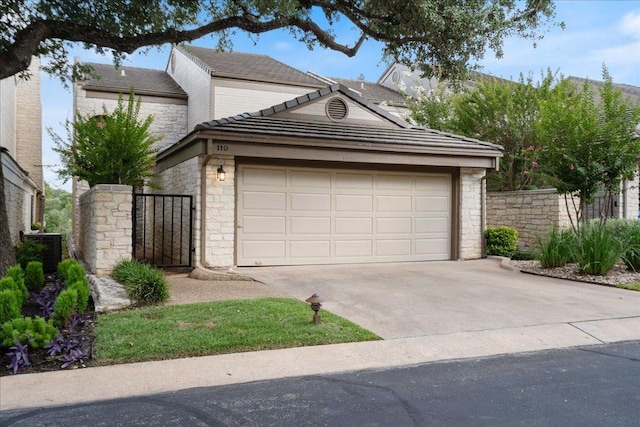 110 W Eagle Dr, The Hills, TX 78738 - view of front facade with stone siding, driveway, a garage, a tiled roof, and a gate
