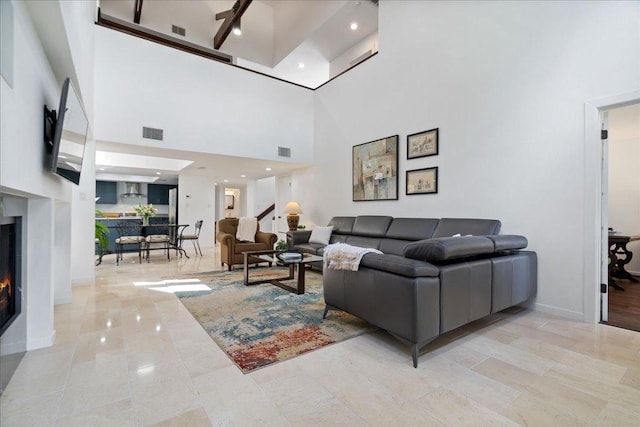 110 W Eagle Dr, The Hills, TX 78738 - living room featuring a towering ceiling and a lit fireplace