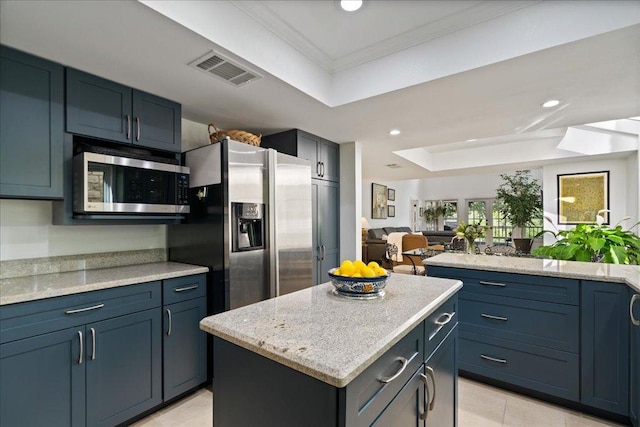 110 W Eagle Dr, The Hills, TX 78738 - kitchen with stainless steel appliances, a raised ceiling, crown molding, a kitchen island, and light tile patterned floors