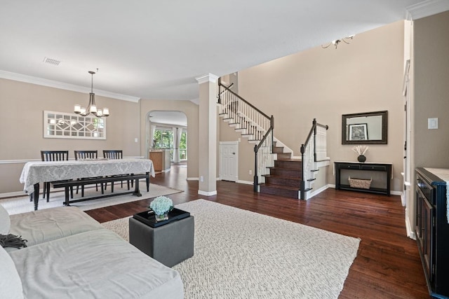 2743 Grimes Ranch Rd, Austin, TX 78732 - living area featuring arched walkways, a chandelier, dark wood-style floors, stairs, and crown molding