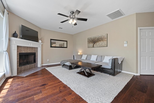 2743 Grimes Ranch Rd, Austin, TX 78732 - living room with wood finished floors, a ceiling fan, and a tile fireplace