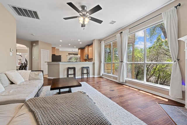 2743 Grimes Ranch Rd, Austin, TX 78732 - living area featuring wood finished floors, ceiling fan, arched walkways, and recessed lighting