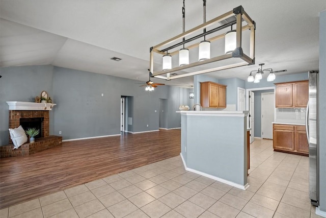 1503 Sherry Dr, Taylor, TX 76574 - kitchen with light tile patterned floors, open floor plan, a ceiling fan, freestanding refrigerator, and vaulted ceiling