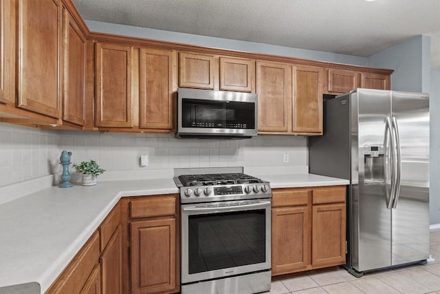 1503 Sherry Dr, Taylor, TX 76574 - kitchen with appliances with stainless steel finishes, brown cabinetry, light countertops, and decorative backsplash