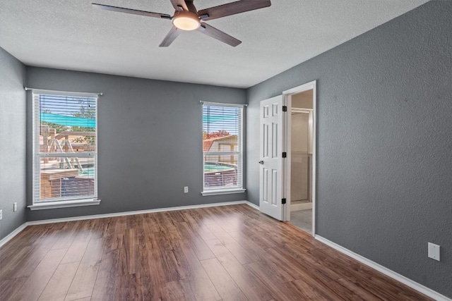 1503 Sherry Dr, Taylor, TX 76574 - unfurnished bedroom with wood finished floors, a textured wall, a textured ceiling, and a ceiling fan
