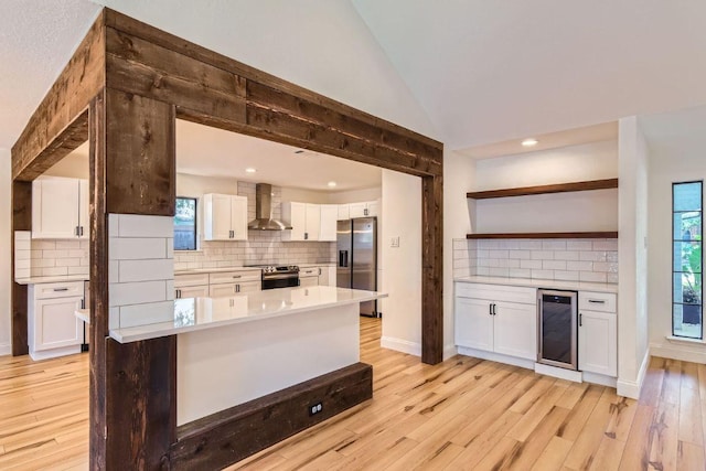 11325 Stormy Ridge Rd, Austin, TX 78739 - kitchen with wall chimney exhaust hood, appliances with stainless steel finishes, beverage cooler, white cabinetry, and light countertops