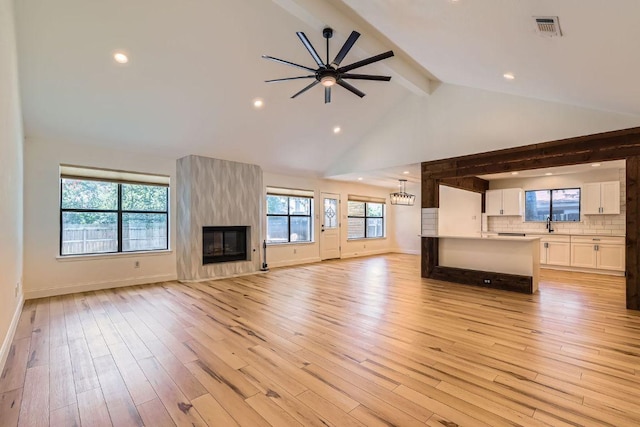 11325 Stormy Ridge Rd, Austin, TX 78739 - unfurnished living room featuring beam ceiling, light wood-type flooring, ceiling fan, a large fireplace, and recessed lighting