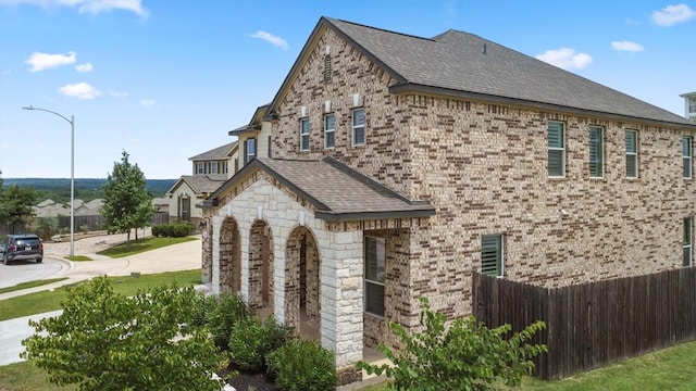 7016 Lickeen Ct, Austin, TX 78744 - view of home's exterior featuring roof with shingles, brick siding, and stone siding
