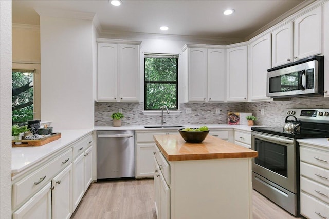 1303UNIT13A N Cuernavaca Dr Unit A13, Austin, TX 78733 - kitchen featuring stainless steel appliances, butcher block counters, ornamental molding, light wood finished floors, and tasteful backsplash