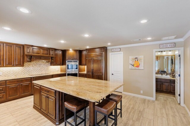 110 Lost River Rd, Georgetown, TX 78628 - kitchen with stainless steel double oven, a kitchen breakfast bar, light stone countertops, tasteful backsplash, and ornamental molding