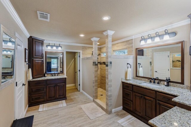 110 Lost River Rd, Georgetown, TX 78628 - bathroom featuring decorative columns, a walk in shower, two vanities, ornamental molding, and recessed lighting