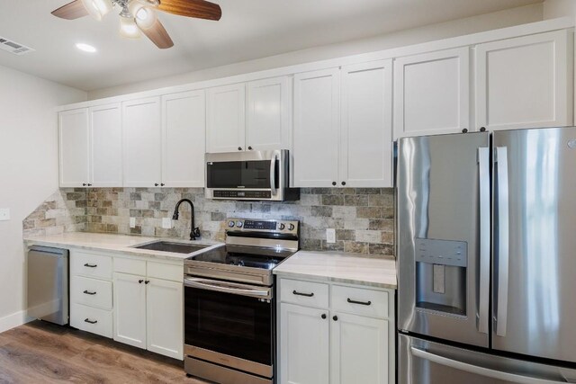110 Lost River Rd, Georgetown, TX 78628 - kitchen with appliances with stainless steel finishes, ceiling fan, wood finished floors, tasteful backsplash, and recessed lighting