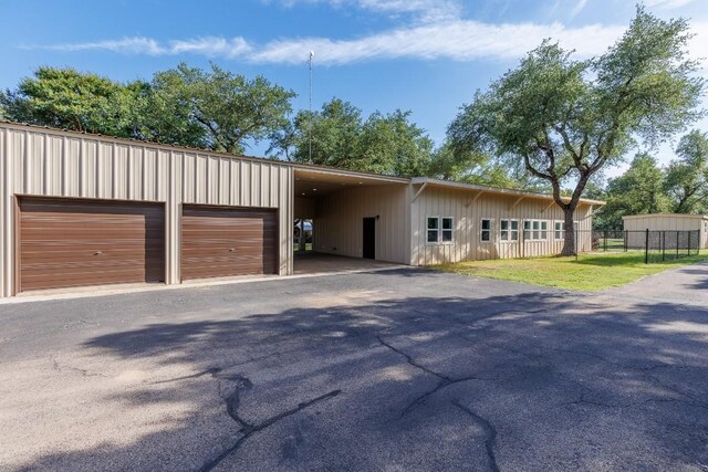 110 Lost River Rd, Georgetown, TX 78628 - view of front of house featuring board and batten siding, asphalt driveway, a garage, and an outdoor structure