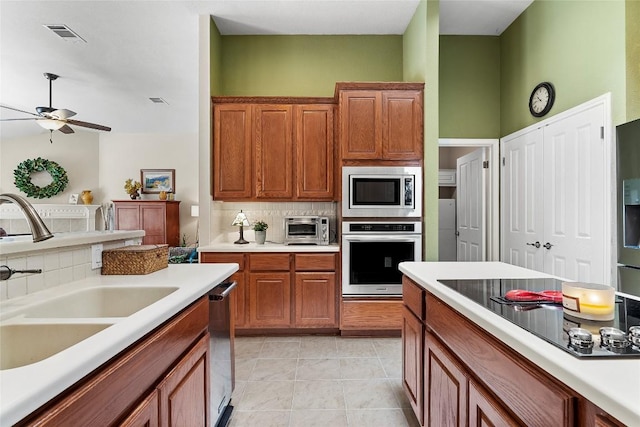 10628 Indigo Broom Loop, Austin, TX 78733 - kitchen with appliances with stainless steel finishes, decorative backsplash, light countertops, and ceiling fan