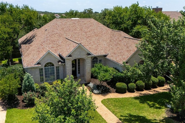 10628 Indigo Broom Loop, Austin, TX 78733 - view of front of home featuring stone siding, roof with shingles, and a front lawn