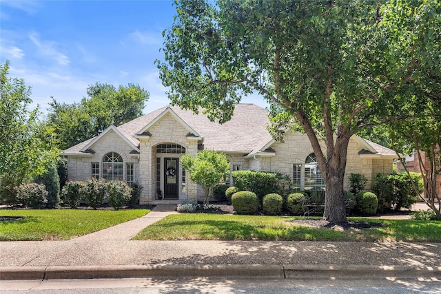 10628 Indigo Broom Loop, Austin, TX 78733 - french country inspired facade featuring stone siding, a front lawn, and roof with shingles