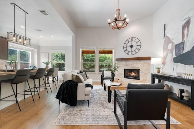 18517 Tanner Bayou Loop, Austin, TX 78738 - living room featuring a chandelier, light wood-style flooring, a stone fireplace, and recessed lighting