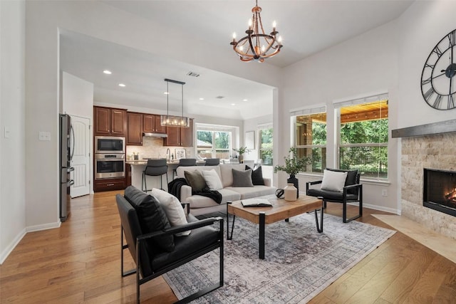 18517 Tanner Bayou Loop, Austin, TX 78738 - living area with light wood finished floors, a chandelier, a fireplace, and recessed lighting