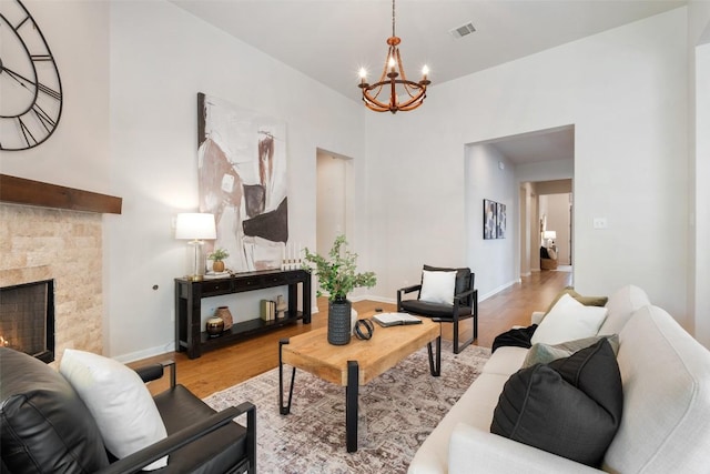 18517 Tanner Bayou Loop, Austin, TX 78738 - living room with a chandelier, wood finished floors, and a warm lit fireplace