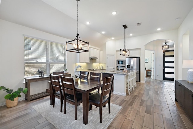 22300 Chipotle Pass, Spicewood, TX 78669 - dining space with arched walkways, light wood-style flooring, recessed lighting, and a chandelier
