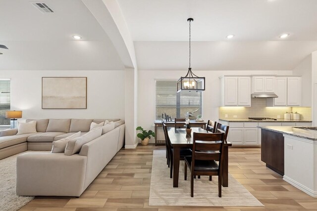 22300 Chipotle Pass, Spicewood, TX 78669 - living room featuring light wood-style floors, recessed lighting, a chandelier, and arched walkways