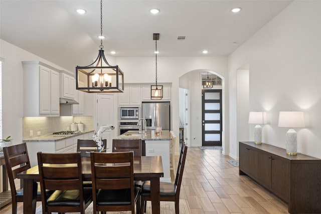 22300 Chipotle Pass, Spicewood, TX 78669 - dining area with a chandelier, arched walkways, and recessed lighting