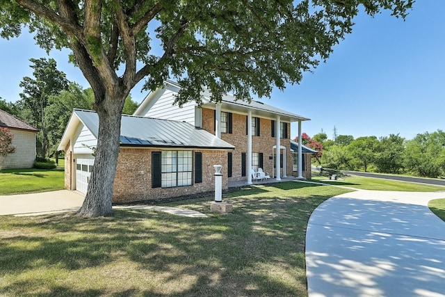 608 Sombrero Dr, Horseshoe Bay, TX 78657 - neoclassical / greek revival house with brick siding, concrete driveway, an attached garage, a standing seam roof, and a front lawn