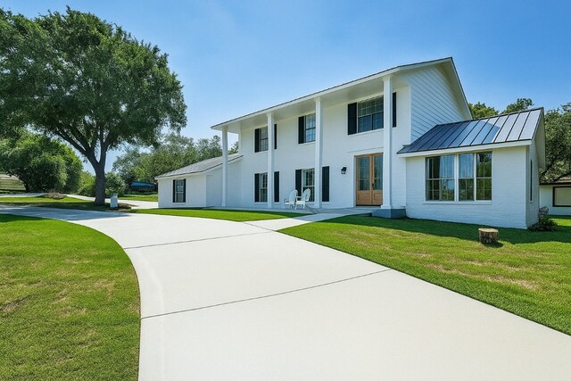 608 Sombrero Dr, Horseshoe Bay, TX 78657 - view of front of home with a standing seam roof, a front yard, and a metal roof