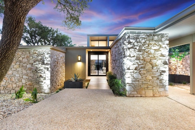 821 Malabar St, Austin, TX 78734 - exterior entry at dusk featuring stone siding