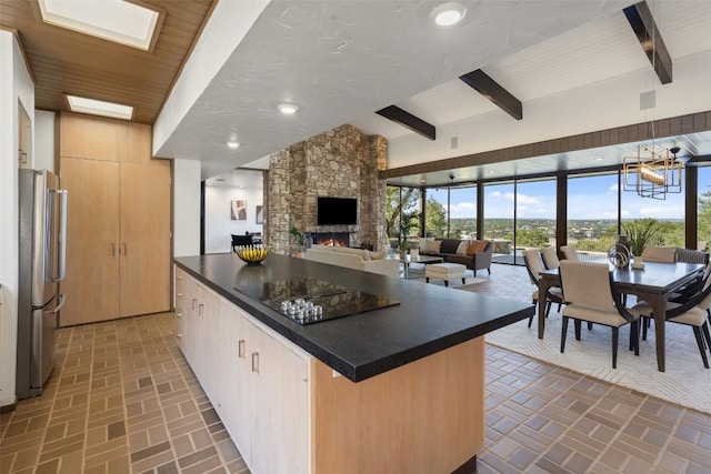821 Malabar St, Austin, TX 78734 - kitchen with brick patterned flooring, freestanding refrigerator, dark countertops, and beamed ceiling