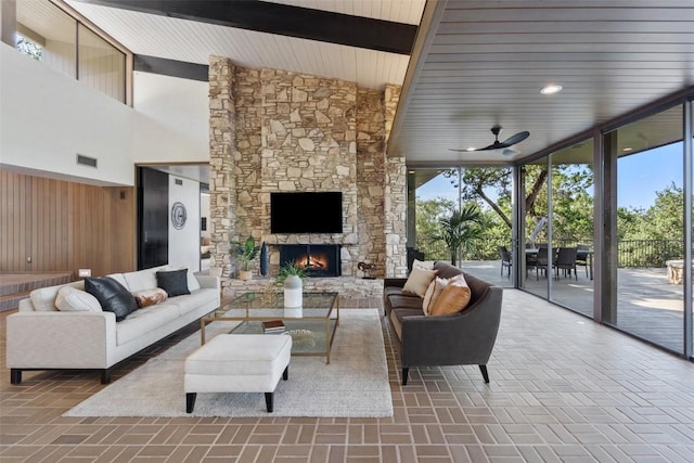 821 Malabar St, Austin, TX 78734 - living room with plenty of natural light, a ceiling fan, a stone fireplace, brick floors, and wooden walls