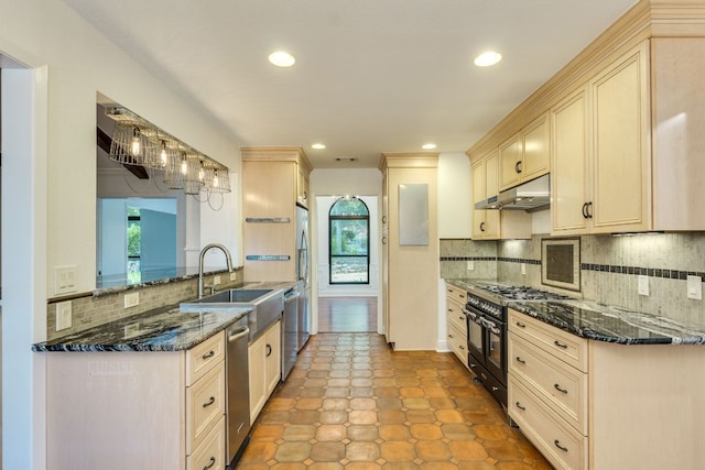 10701 Glass Mountain Trl, Austin, TX 78750 - kitchen with appliances with stainless steel finishes, under cabinet range hood, tasteful backsplash, dark stone counters, and recessed lighting