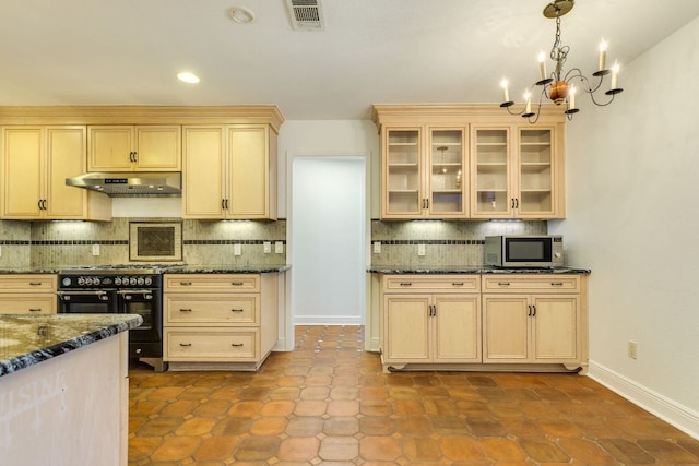 10701 Glass Mountain Trl, Austin, TX 78750 - kitchen featuring under cabinet range hood, stainless steel microwave, range with two ovens, backsplash, and a chandelier