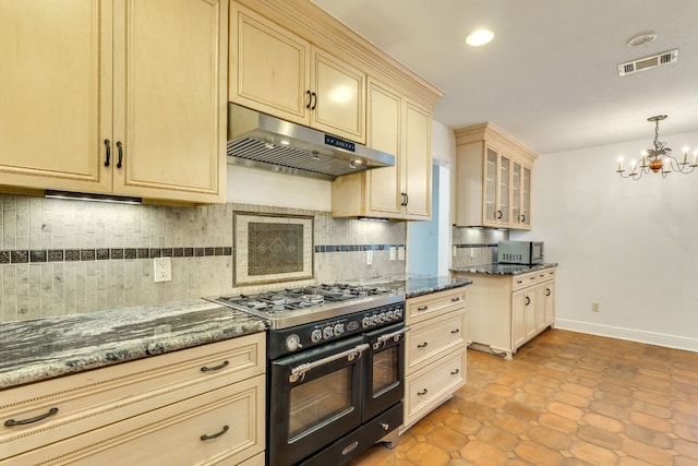 10701 Glass Mountain Trl, Austin, TX 78750 - kitchen featuring under cabinet range hood, double oven range, cream cabinetry, a chandelier, and tasteful backsplash