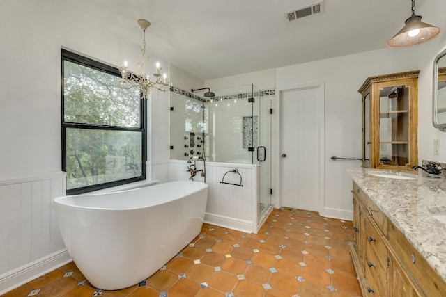 10701 Glass Mountain Trl, Austin, TX 78750 - full bath with plenty of natural light, a shower stall, a soaking tub, a wainscoted wall, and a chandelier