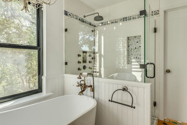 10701 Glass Mountain Trl, Austin, TX 78750 - bathroom with a soaking tub, a shower stall, healthy amount of natural light, a wainscoted wall, and a decorative wall